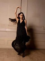 Vestido largo negro con escote en V, breteles finos con lazo y bordados florales a tono. Corte imperio y falda amplia con volados. 