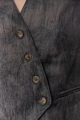 Chaleco grafito con cuello en V, cierre frontal con botones y bolsillos delanteros.