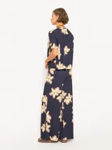 Pantalón de punto azul marino con estampado de flores blancas y marrones, cintura elastizada y corte amplio en las piernas.