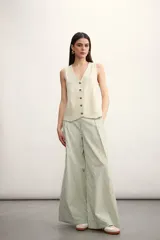 Pantalón palazzo a rayas verticales color beige y blanco, de tiro alto y corte amplio.