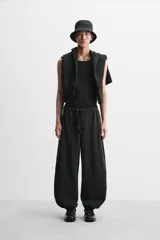 Pantalón de jogging negro, corte balloon fit, con cintura elástica ajustable con cordón, bolsillos laterales y trasero, costura frontal en las perneras y puños elásticos en los tobillos.