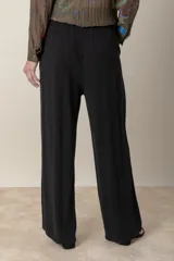 Pantalón ancho color beige de lino y rayón, con cintura elastizada ajustable con cordón y bolsillos laterales.