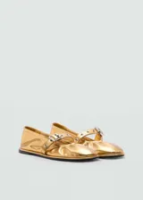 Zapato tipo bailarina color dorado, con punta redonda y tira sobre el empeine con hebilla metálica.