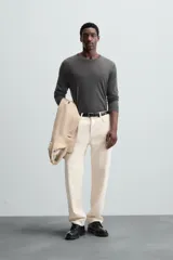 Jersey negro de lana con acabado mercerizado, corte relaxed fit, cuello redondo y mangas largas con terminaciones en rib.