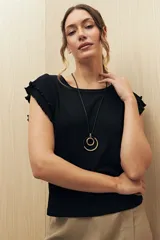 Top color rosado de tejido de punto acanalado, con cuello redondo y mangas cortas con volados.