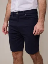 Bermuda de jean color beige, corte recto, con cinco bolsillos y presillas para cinturón.