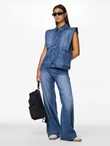 Chaleco denim azul de corte holgado con cierre de botones. Tejido suave con estructura ligera.