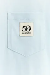 Camiseta negra de algodón con cuello redondo y manga corta. Tiene un bolsillo de parche en el pecho con el logo del 50 aniversario.