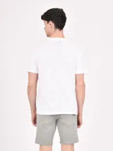 Remera blanca de manga corta con cuello redondo y estampado con la frase "New York City Tennis 1989" y una ilustración de dos jugadores de tenis.