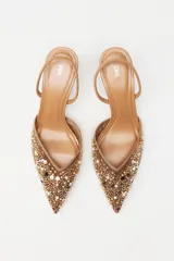 Zapato destalonado color beige con puntera fina, confeccionado en mesh con abalorios y tira trasera elástica. Tacón fino de 8 cm.