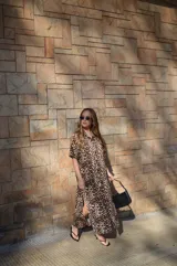 Vestido camisero de muselina color negro, de largo midi, con cuello clásico, manga corta y cierre frontal con botones.