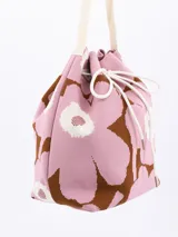 Bolso bandolera tipo bucket con estampado de flores en blanco y negro, con ajuste superior de cordón y correa larga de hombro negra.