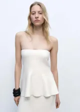 Top bandeau blanco de punto fino con corte peplum.