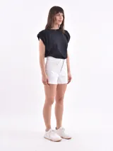 Short de jean blanco con corte a la cintura y terminación desflecada.