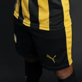 Short de fútbol Puma del Club Atlético Peñarol, modelo Home, color negro con franjas laterales amarillas. Presenta el escudo del club con estrellas y el logo Puma en amarillo.