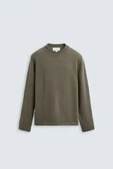 Jersey regular fit color verde oliva, tejido en hilatura con mezcla de algodón y 13% de cashmere. Tiene cuello redondo y manga larga, con acabados en rib con detalle de vuelta.