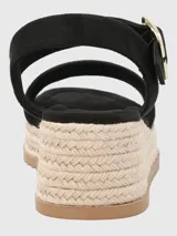 Sandalias negras con plataforma de yute, tira ancha sobre los dedos y tira con hebilla dorada alrededor del tobillo.