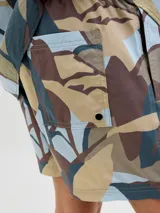 Short de baño con estampado abstracto en tonos celeste, marrón, beige y gris. Tiene cintura elástica con cordón ajustable, bolsillos laterales y un bolsillo trasero.