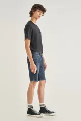 Bermuda de jean azul con lavado medio, corte recto y largo a la rodilla. Diseño clásico con bolsillos delanteros y traseros.