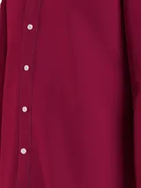 Camisa de vestir color borgoña, de corte regular, con cuello abotonado, mangas largas y logo de Tommy Hilfiger bordado en el pecho.