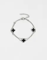 Pulsera plateada de doble cadena con bolitas y dijes de flor de cuatro pétalos esmaltados en negro.