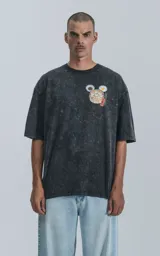 Remera negra con efecto acid wash, corte holgado y estampa frontal de Bao, personaje de Disney.