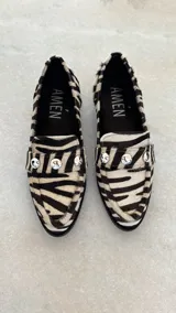 Mocasines de cuero con estampado animal print de cebra en blanco y negro, con apliques de strass plateados.