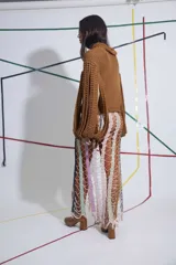 Sweater tejido a mano color marrón, con cuello alto y mangas con aberturas.