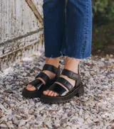 Sandalias negras de cuero vacuno con suela de goma deportiva, plataforma de 4 cm y ajuste con velcro.