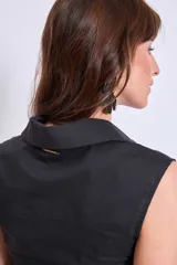 Camisa sin mangas color negro con cuello clásico, abotonada al frente y detalle de strass en el frente.