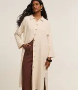 Vestido chemise recto, confeccionado en viscolino con 15% de lino, con cuello, abotonado delantero y mangas 7/8. Color beige claro.