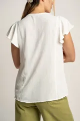 Blusa blanca con escote en V, mangas cortas con volados y cierre frontal con botones.
