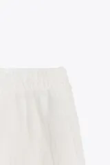 Falda midi color blanco, semitransparente, de tiro medio con cintura elástica, forro corto interior y abertura en la espalda.