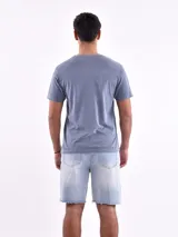 Remera celeste de corte recto y mangas cortas, con estampado pequeño en el pecho.