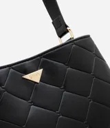 Bolso bandolera pequeño color negro, con textura acolchada en forma de rombos y logo triangular dorado en el frente.