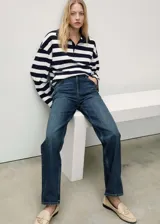 Pantalón de jean azul oscuro, de corte recto, tiro medio y cinco bolsillos.