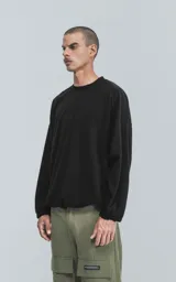 Sweater negro de corte holgado con cuello redondo y mangas largas con puños ajustados.