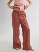 Pantalón de lino color ladrillo, de corte recto con cintura elastizada y tajos laterales en el ruedo.