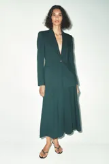 Falda midi verde oscuro con tablas, de tiro alto y cierre trasero con cremallera oculta.