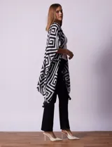 Kimono tejido con estampado geométrico en blanco y negro, con terminación de ruedo con borlas.