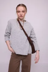 Buzo gris de alpaca y nylon, de corte ligeramente oversize, con cuello redondo, mangas largas y puños.