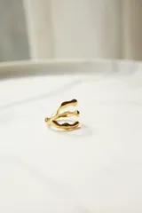 Anillo ajustable de acero quirúrgico con diseño orgánico y texturizado, color dorado.