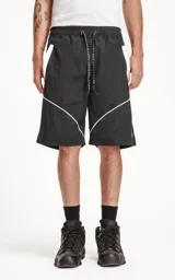 Bermuda negra con recortes blancos, calce oversize de textil liviano, con elástico en la cintura y cordón de ajuste con bolsillos delanteros y traseros.