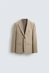 Blazer straight fit color beige confeccionada en tejido con viscosa. Cuello con solapas de muesca y manga larga acabada en puño con botón. Bolsillo de vivo en pecho y bolsillos de plastrón en cadera. Bajo con aberturas en espalda. Cierre frontal de botonadura.
