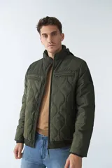 Campera de nylon color verde militar, con capucha, cierre frontal con cremallera, bolsillos laterales y frontales.