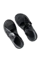 Sandalias de cuero color marrón y blanco, con suela track negra y ajuste con velcro.