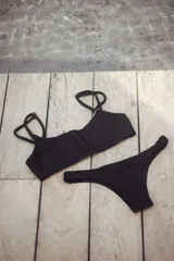 Conjunto de bikini con estampado geométrico en tonos celeste, azul, blanco, amarillo y naranja. El corpiño es bandeau con breteles regulables y lazo en la espalda. La bombacha es vedetina con frunce elástico en los costados.