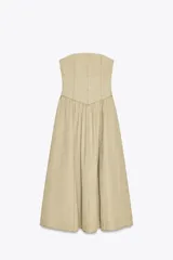 Vestido midi color beige, de corte recto, con escote palabra de honor y hombros descubiertos. Confeccionado en tejido con efecto lavado y detalle de pliegues. Cierre trasero con cremallera metálica.