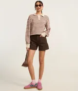 Blusa de manga larga con cuello polo contrastante y botones frontales. Confeccionada en punto texturizado con rayas horizontales en tonos rosa, marrón y crema.