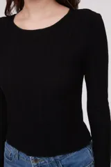 Remera de manga larga entallada de color negro, confeccionada en viscosa con diseño de canale.